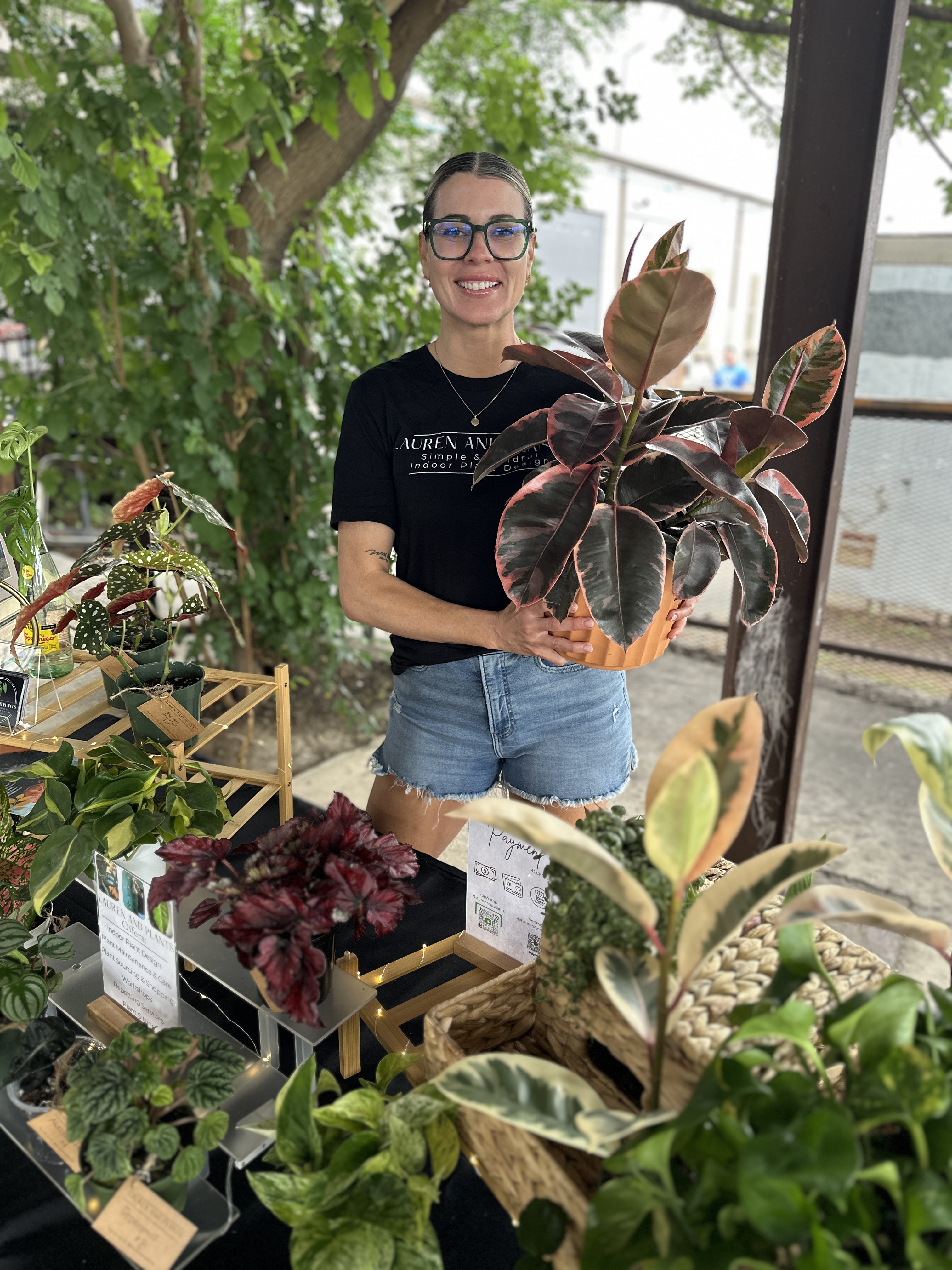 Lauren holding a plant at a local event