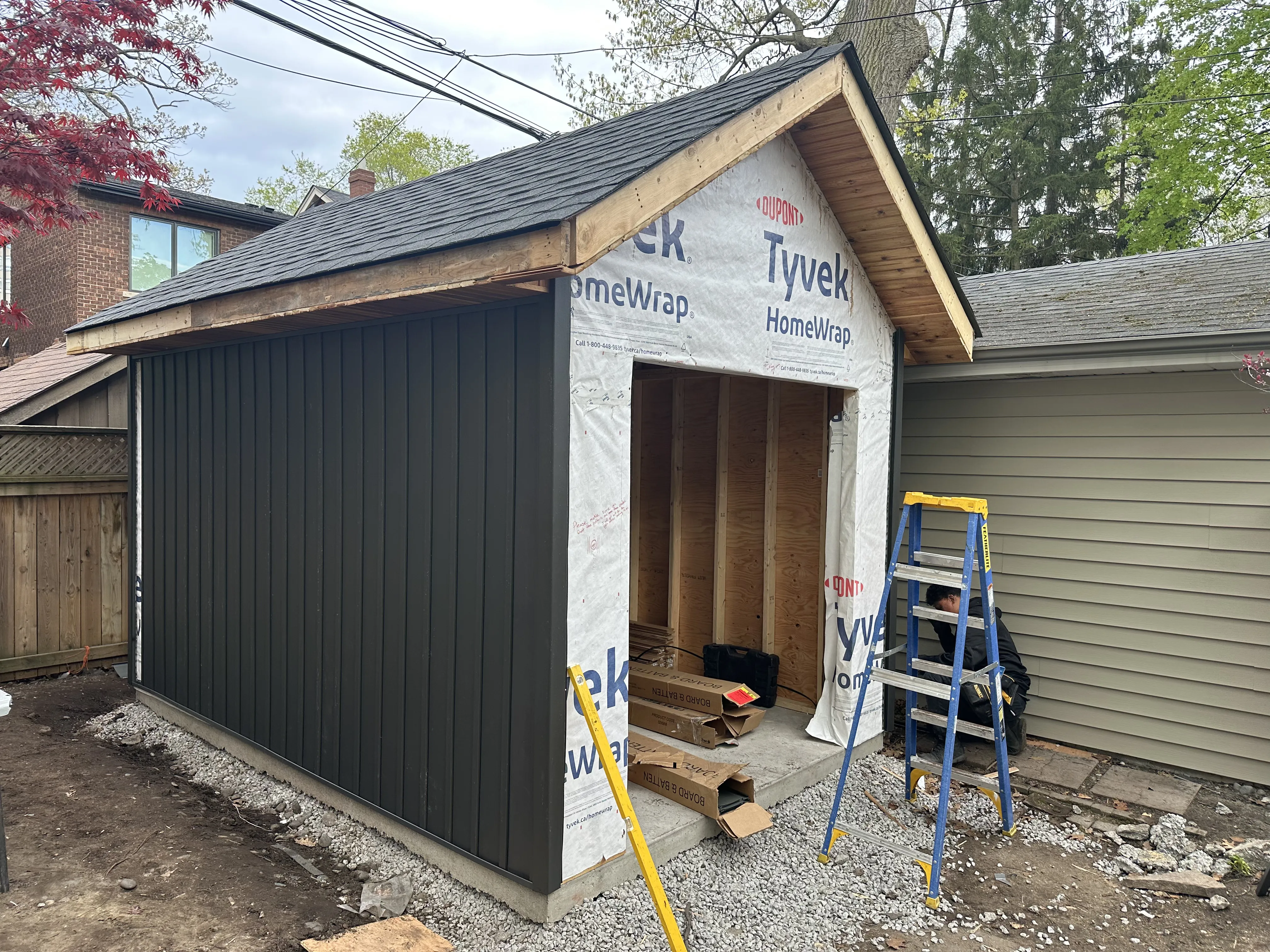 New garage under construction in Toronto with Tyvek wrap and vertical black siding installed New garage under construction in Toronto with Tyvek wrap and vertical black siding installed