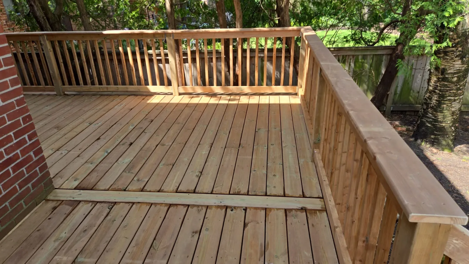 Top view of completed wooden deck with secure railings in backyard Top view of completed wooden deck with secure railings in backyard