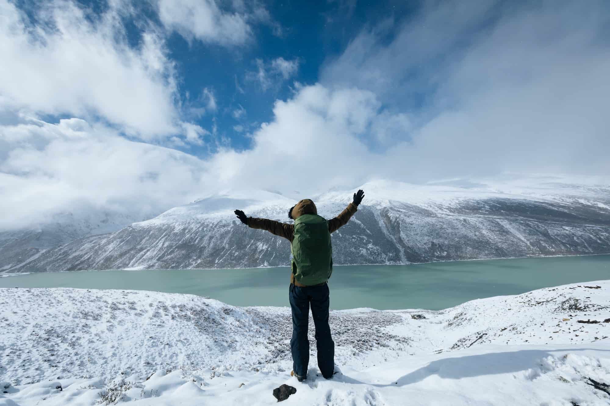 person by snowy lake person by snowy lake