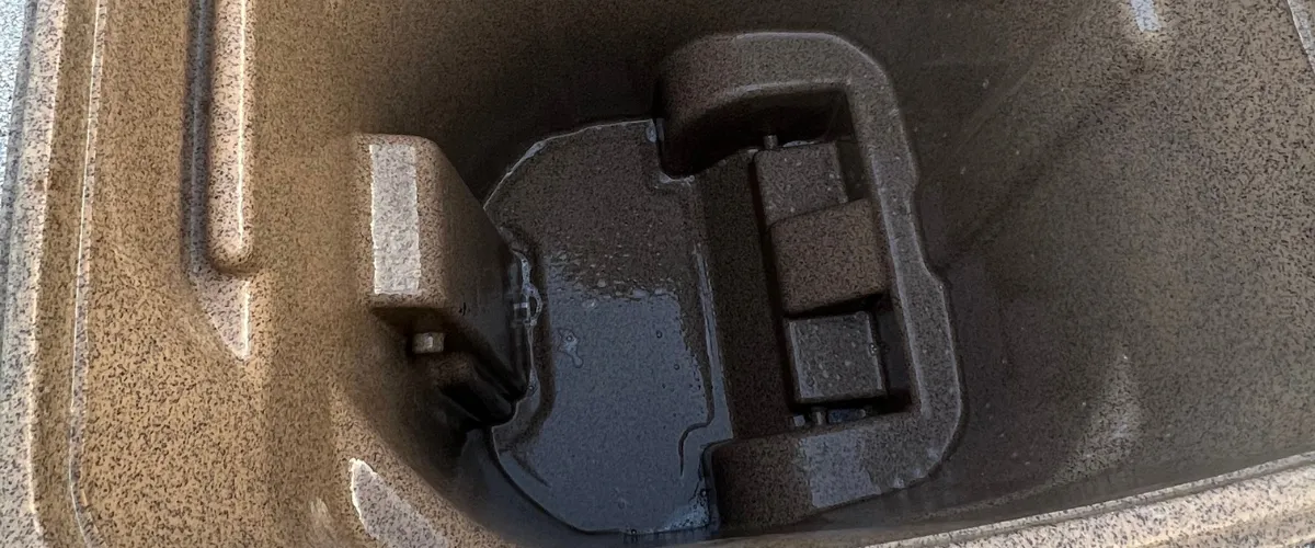 Inside of a brown garbage bin freshly cleaned and rinsed.