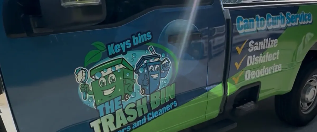 Branded trash bin cleaning service truck with graphics and services listed.