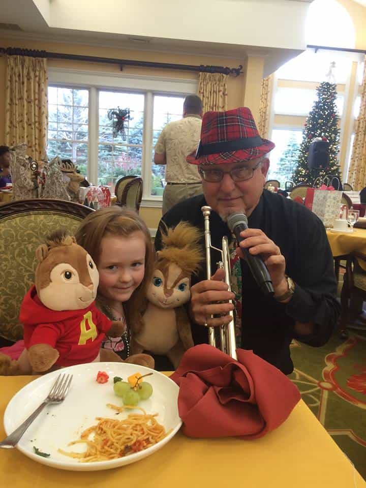 man with trombone posing next to little girl