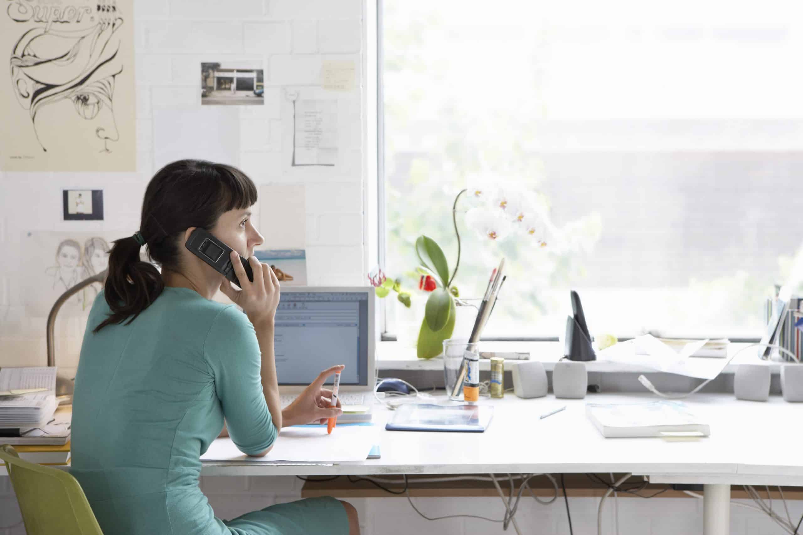 woman talking on phone at her desk