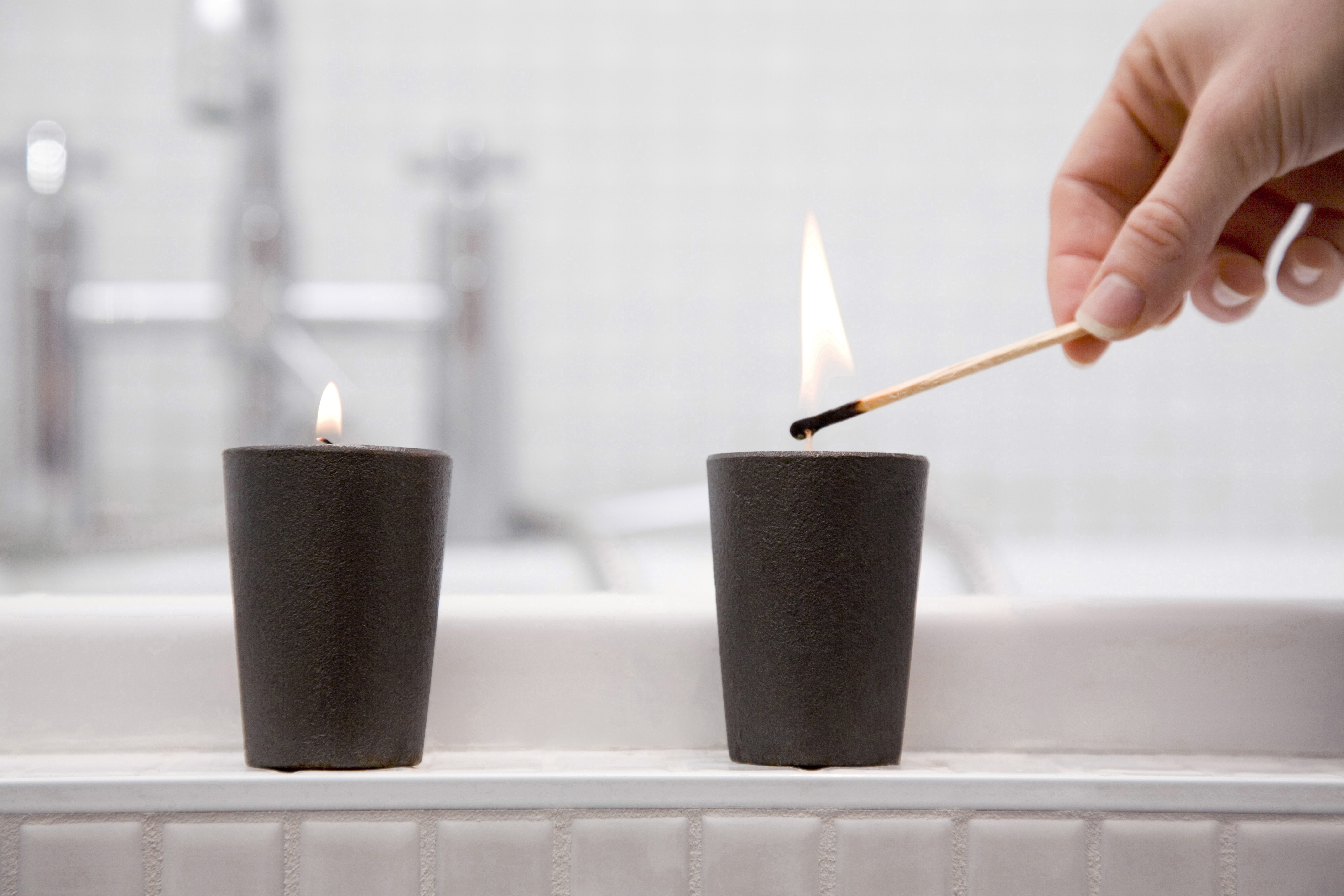 woman's hands lighting two candles