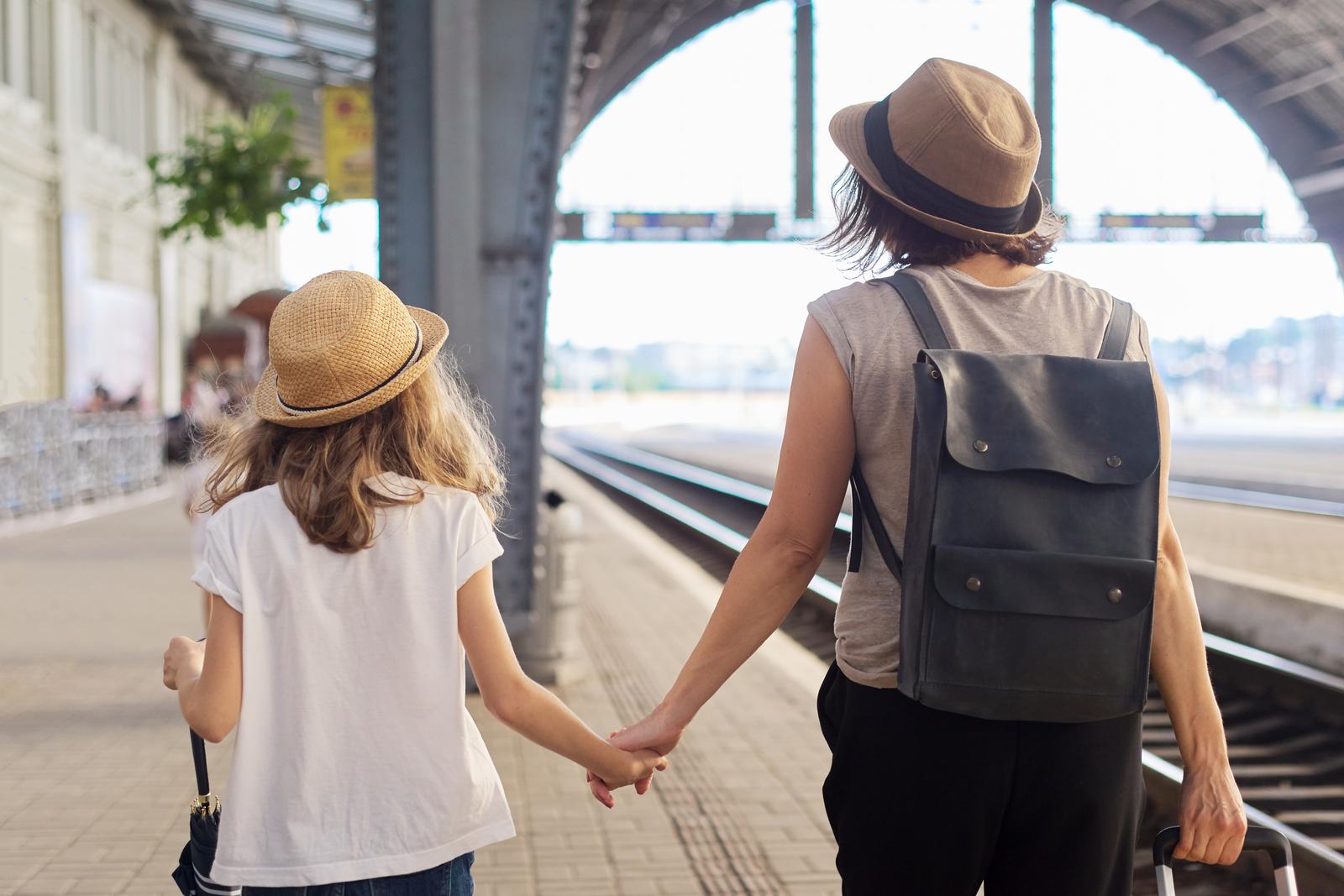 mother and young daughter holding hands walking