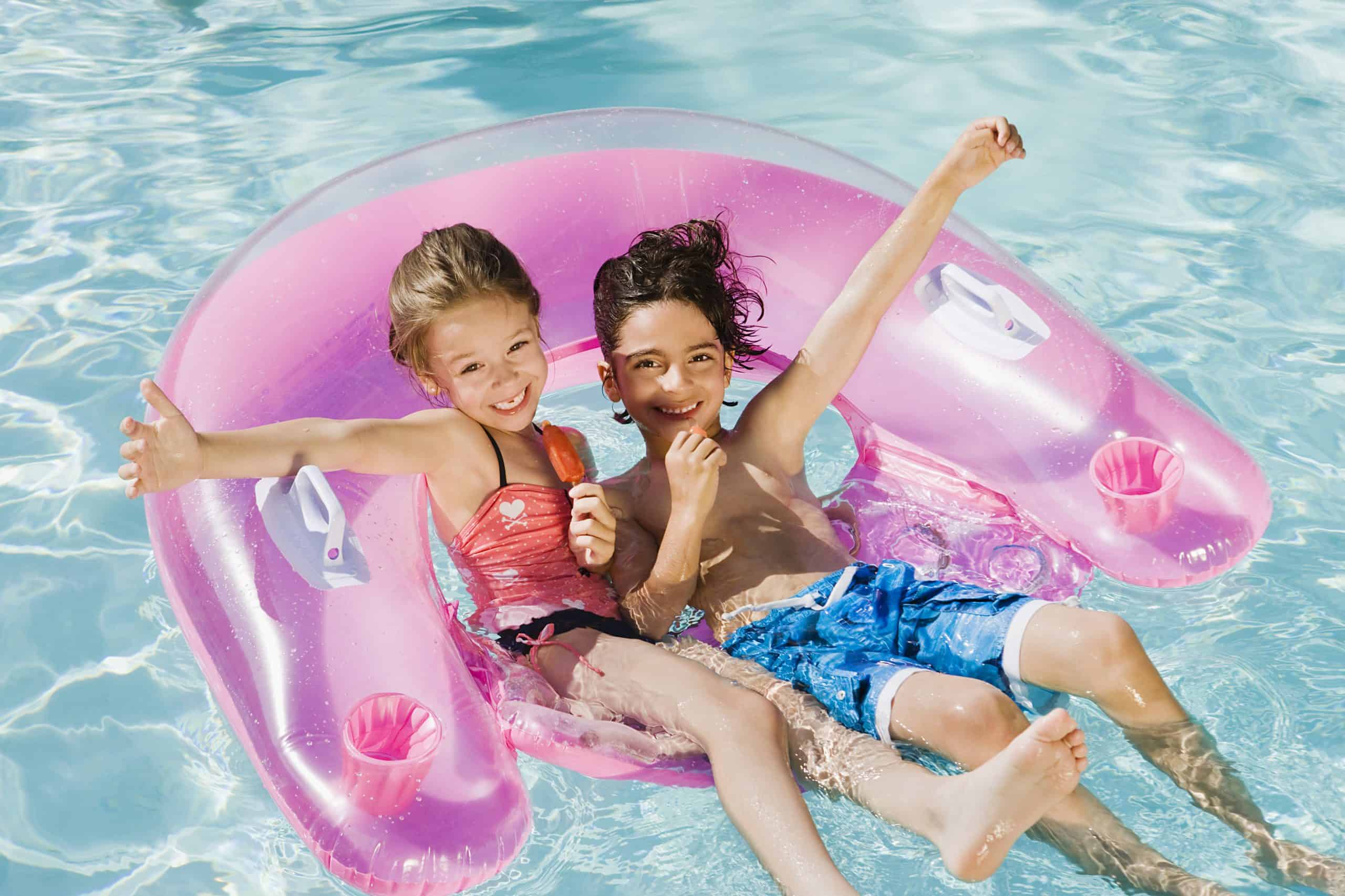 boy and girl in a floatie on the water