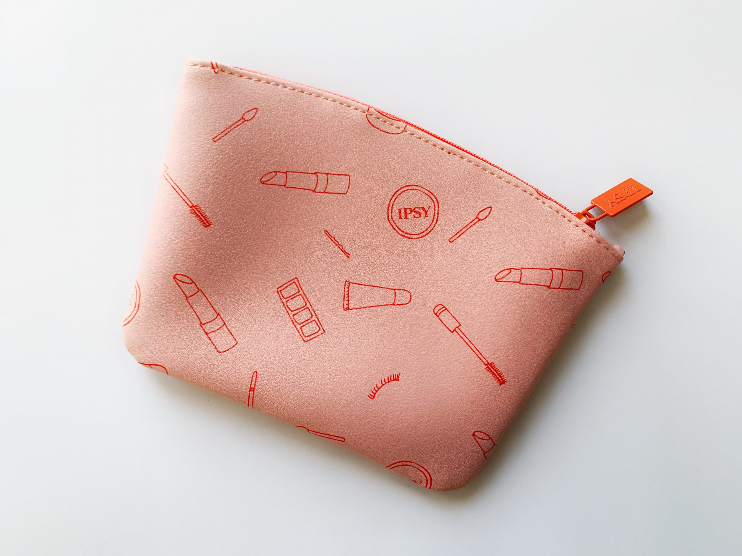 an orange, Ipsy makeup bag with makeup decals on it