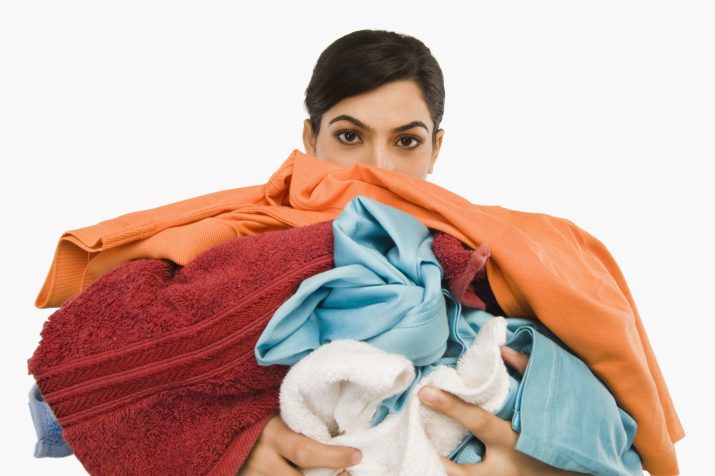 woman holding an armful of clothes
