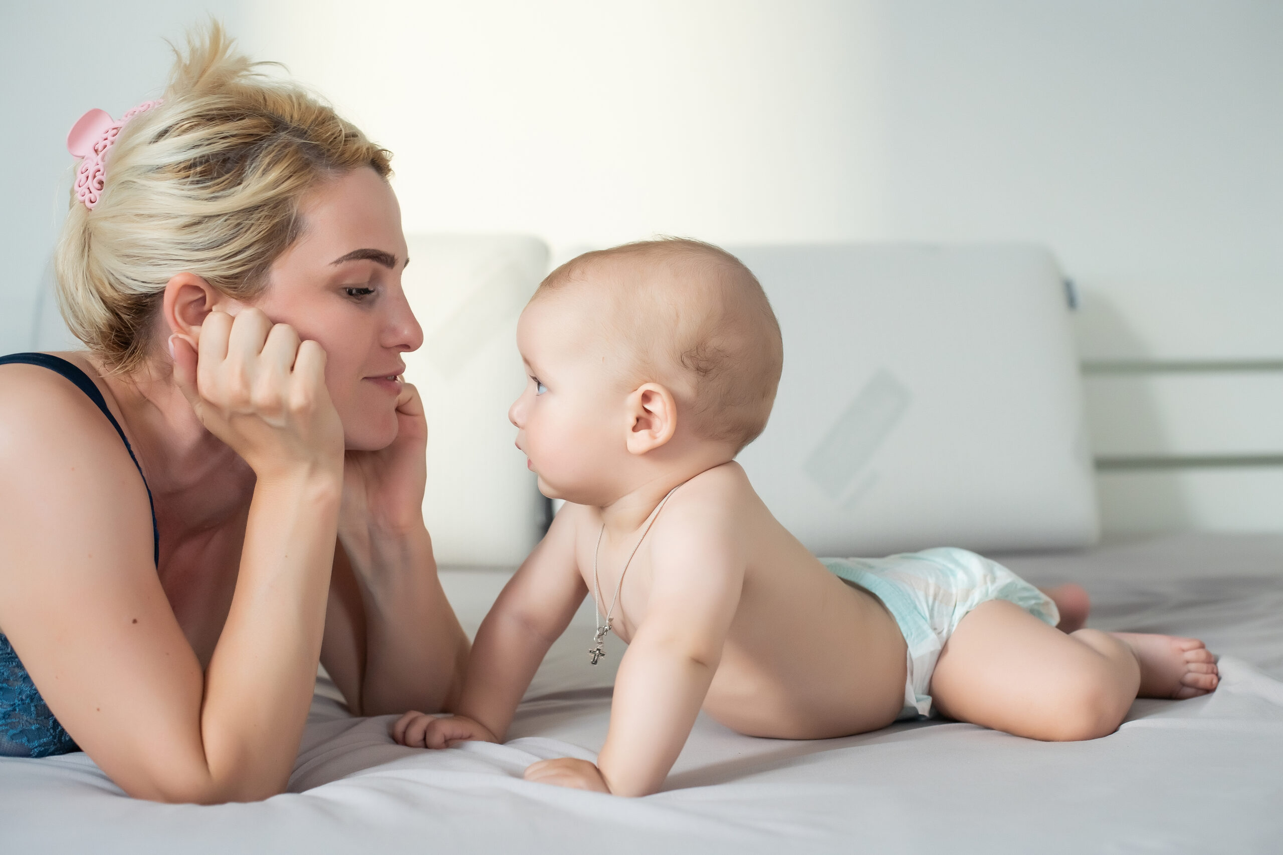 Mother and child on a white bed. 