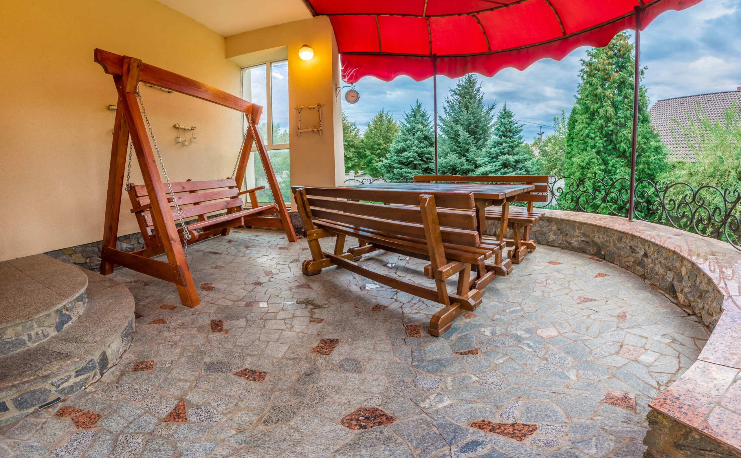 Patio with Wooden table with benches and a swing