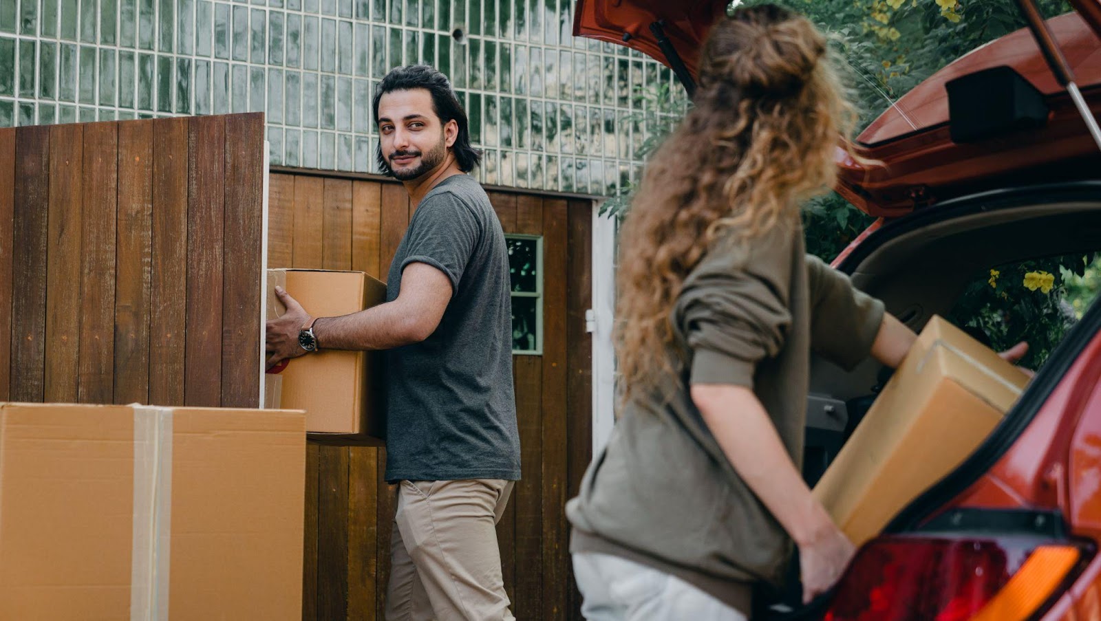 a man and woman moving boxes