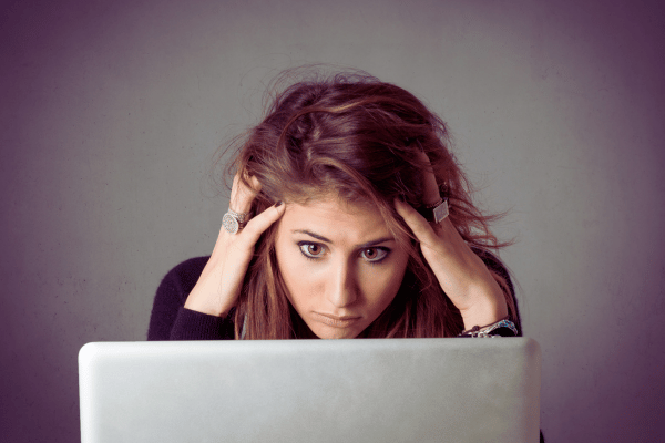 Woman looking worried in front of laptop - let's address some common concerns about running updates on your devices Woman looking worried in front of laptop - let's address some common concerns about running updates on your devices