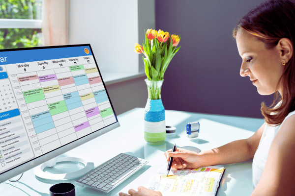 Lady at computer with online calendar open, scheduling times to deal with her emails Lady at computer with online calendar open, scheduling times to deal with her emails