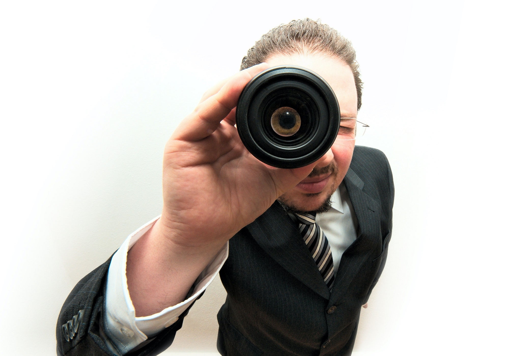 man looking through a camera lens