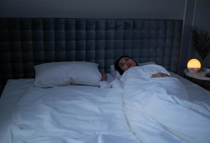 A person lying awake in bed, demonstrating the challenges of sleep disturbances, especially for those in recovery. A person lying awake in bed, demonstrating the challenges of sleep disturbances, especially for those in recovery.
