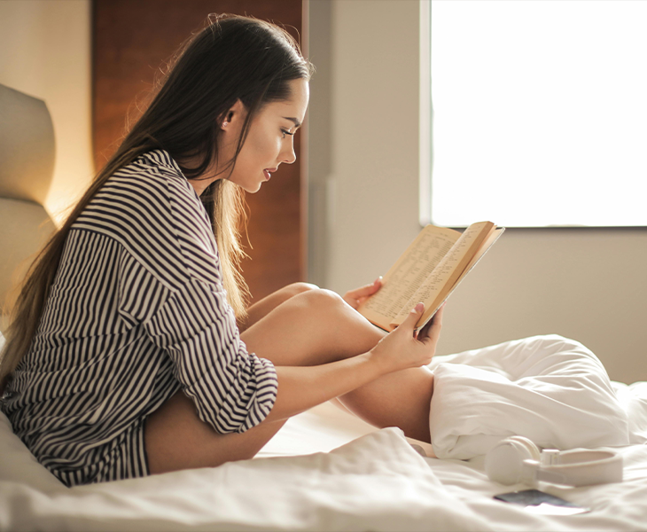Person reading a book before bed, as part of a relaxing bedtime routine. Person reading a book before bed, as part of a relaxing bedtime routine.