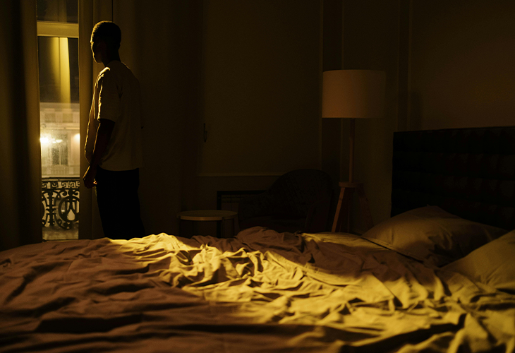 A man staring out a window late at night, struggling with insomnia and restlessness. A man staring out a window late at night, struggling with insomnia and restlessness.