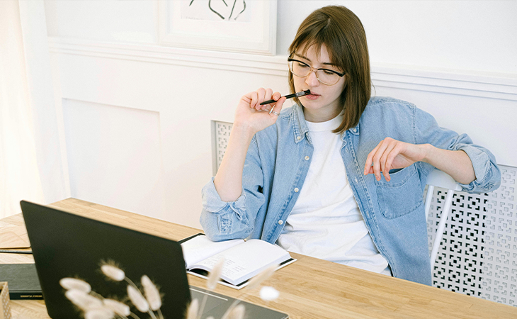 Person creating a personalized stress management plan using a notebook and laptop. Person creating a personalized stress management plan using a notebook and laptop.