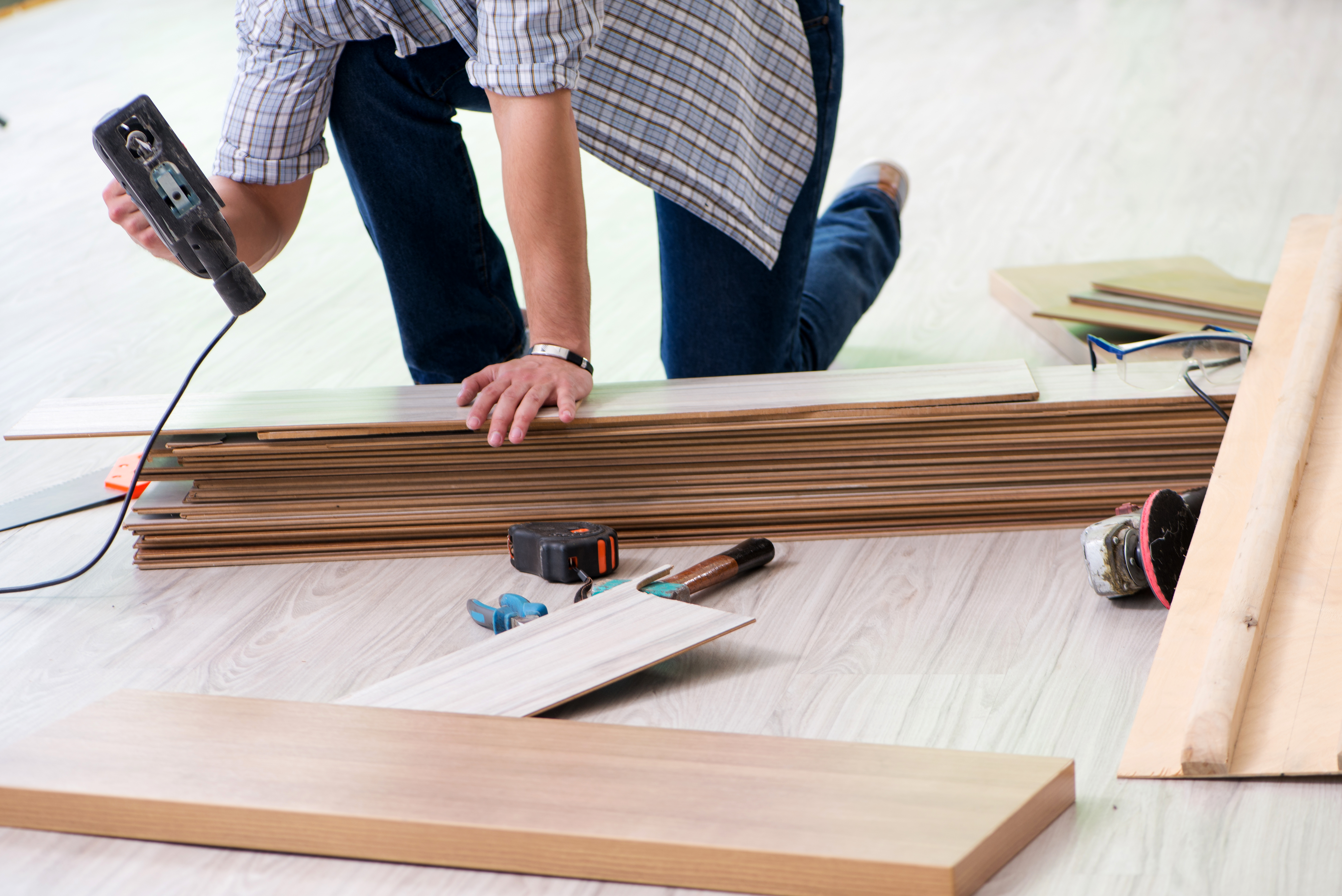 a person holding a drill and a stack of wood