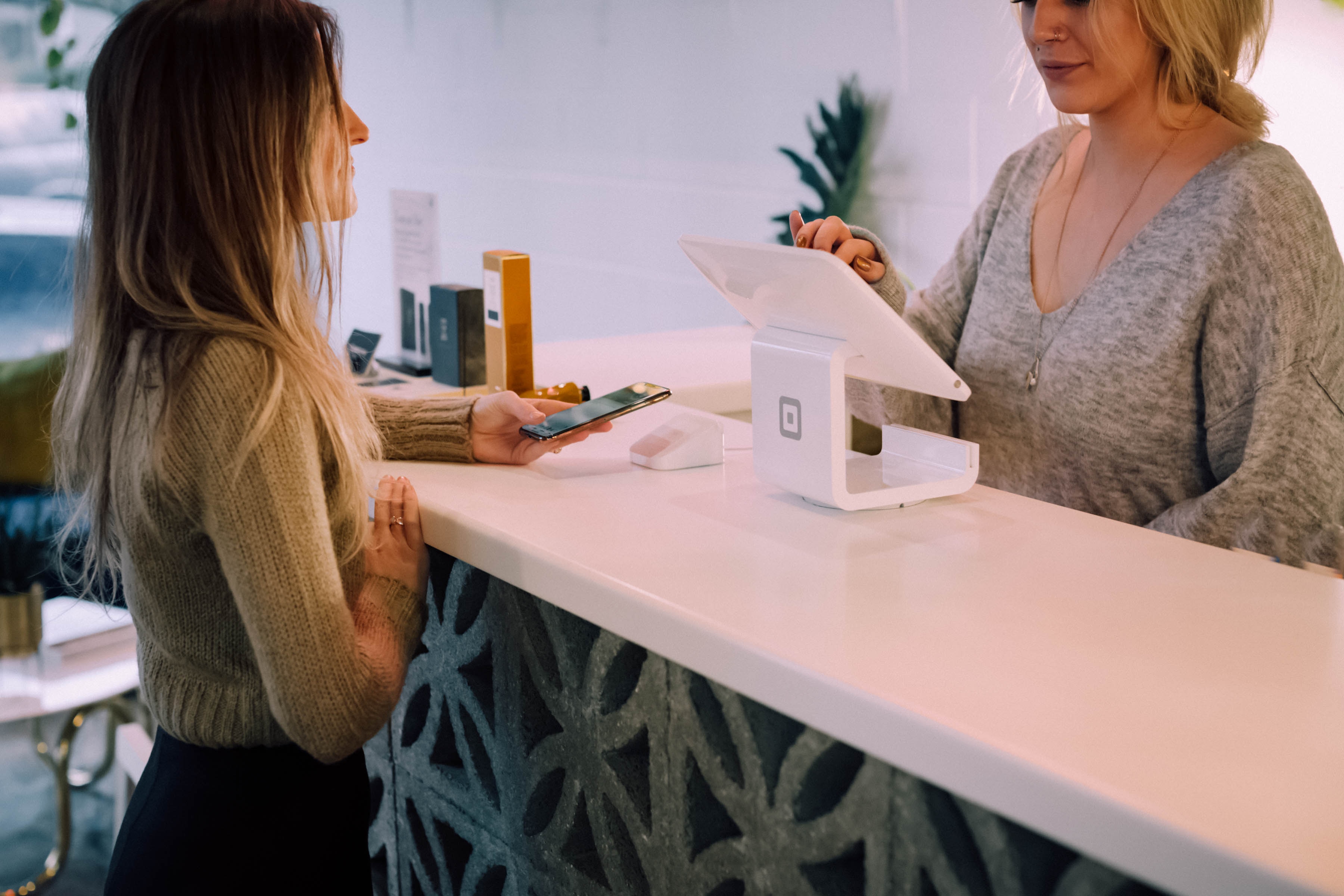 picture of women making a payment at the front desk of a clinic