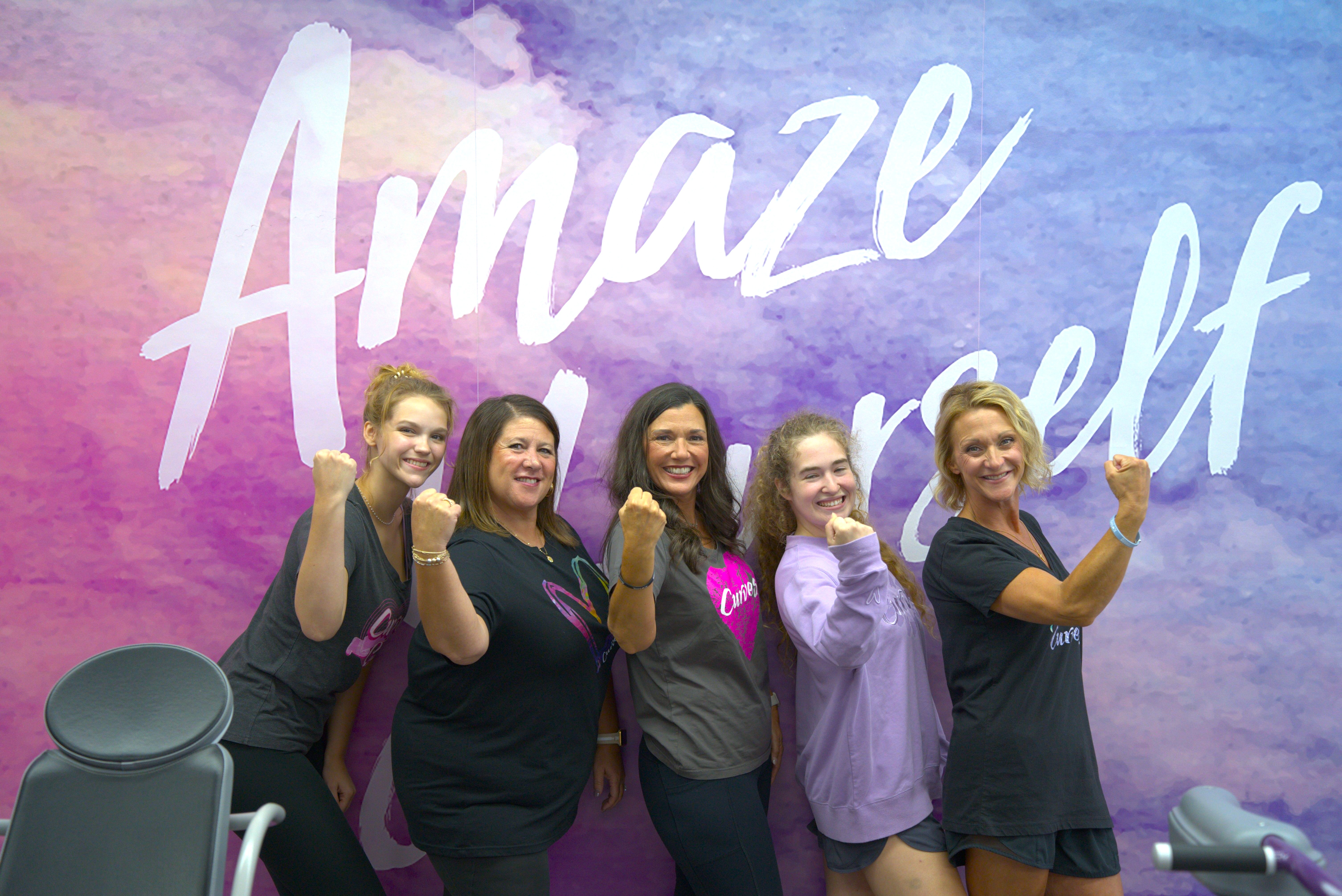Women at Curves club in front of Amaze Yourself sign