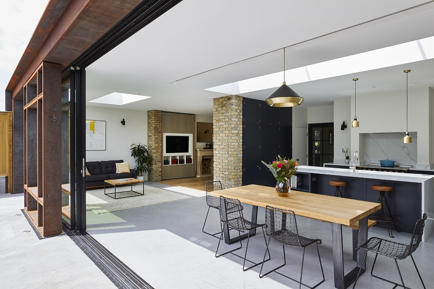 a dining table and chairs in a room with a kitchen and a living room