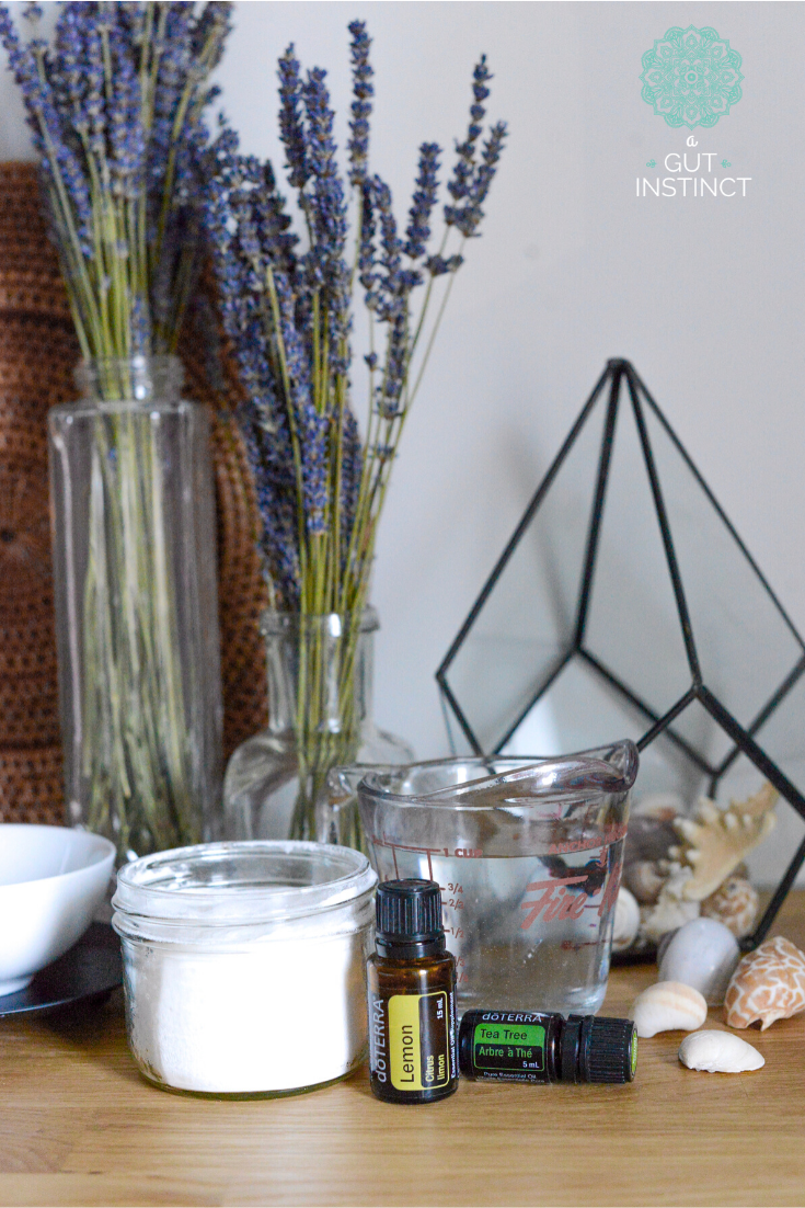 a photo of essential oil bottles, measuring cup, seashells, and vases filled with lavender flowers representing clean and healthy product choices for living in a nontoxic home