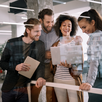 Team of diverse women collaborating in automotive tech workspace, representing visibility in technical roles.