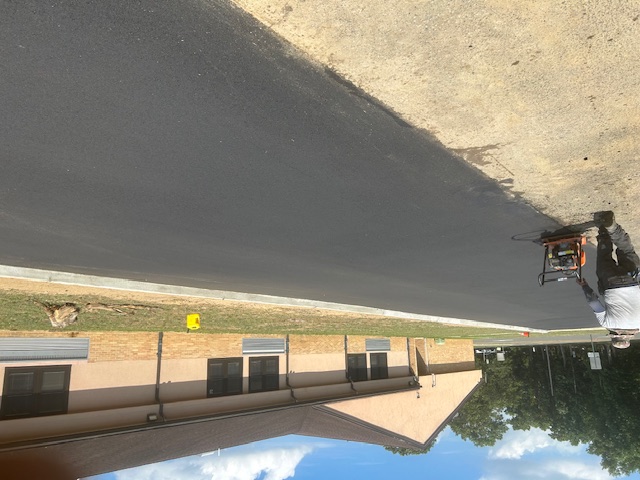 After image of an industrial site where the railroad trench has been filled in with concrete and paved over. The smooth, light-colored concrete surface now covers the previously visible trench, creating a neat and uniform appearance. The area looks clean and well-maintained, indicating the successful completion of the renovation project. Visible sections of construction equipment and safety barriers in the background further emphasize the recently finished work.