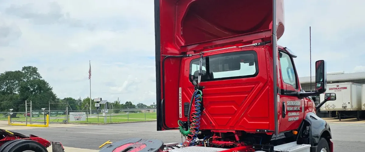 Red Southeastern Freight semi-truck in a cleaning bay with hood open and detailing completed Red Southeastern Freight semi-truck in a cleaning bay with hood open and detailing completed