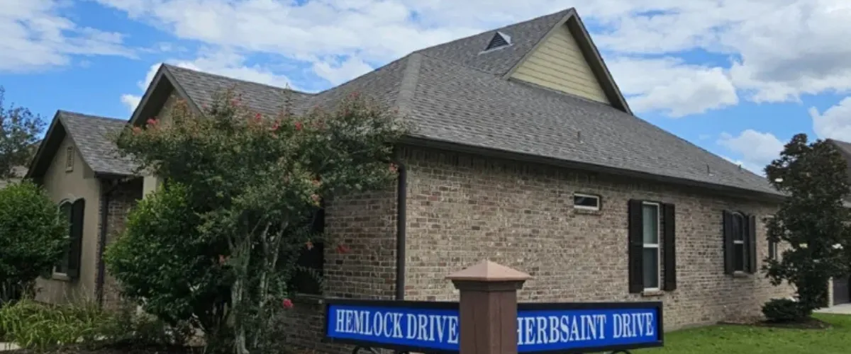 Brick house located at the corner of Hemlock Drive and Herbsaint Drive