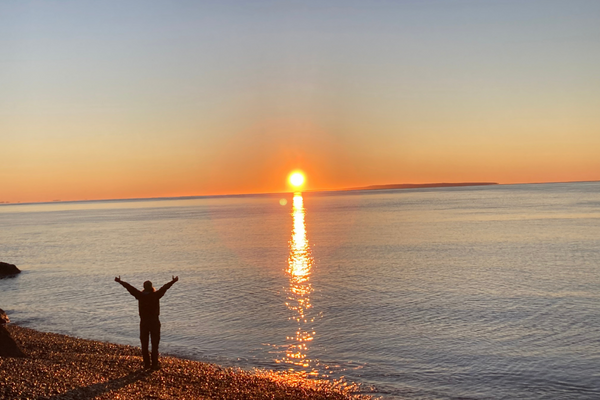 man facing the ocean sunset