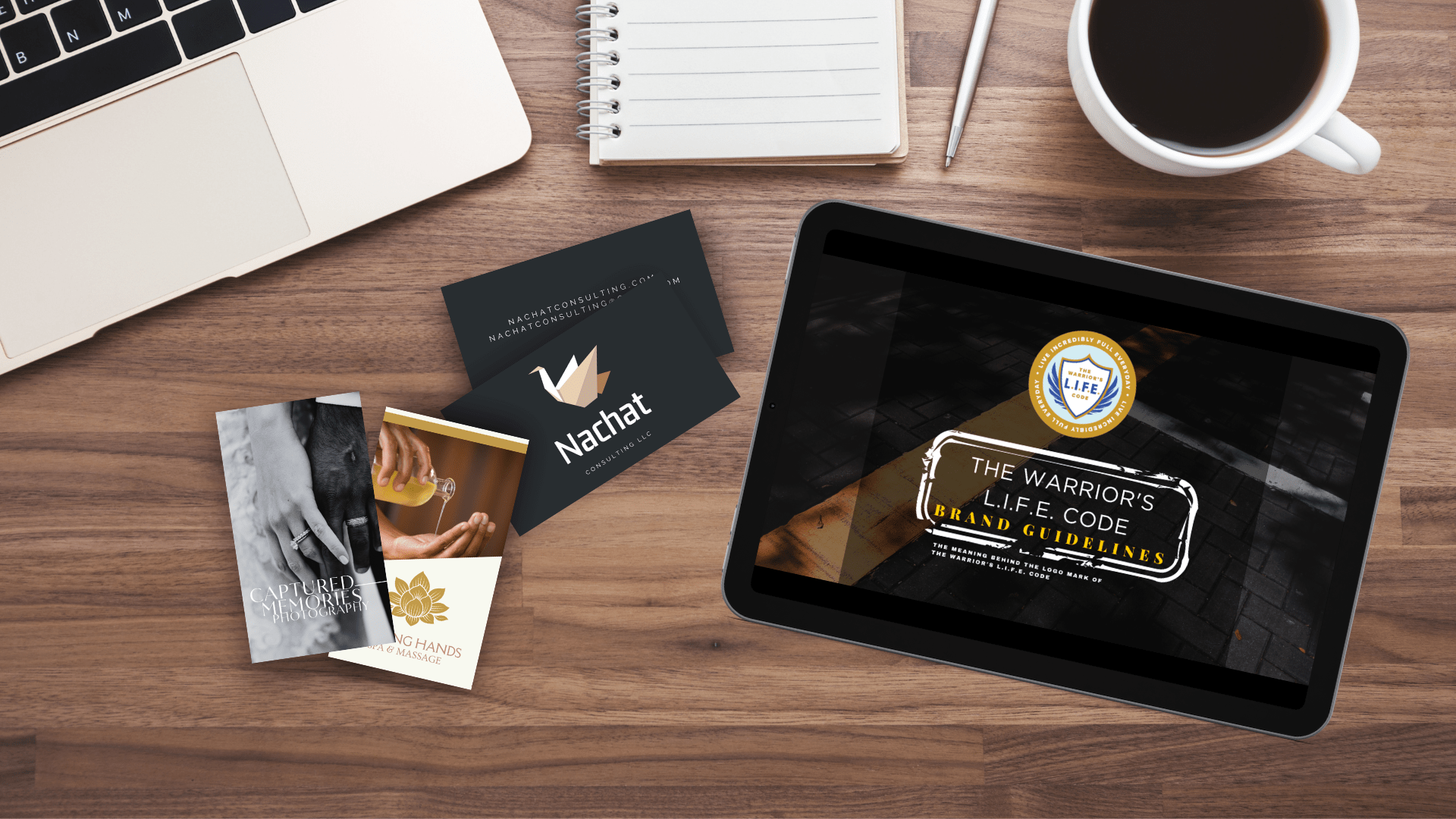 Desk with Nachat Consulting LLC branding materials, including business cards, a notebook, a laptop, and a tablet displaying brand guidelines. Desk with Nachat Consulting LLC branding materials, including business cards, a notebook, a laptop, and a tablet displaying brand guidelines.