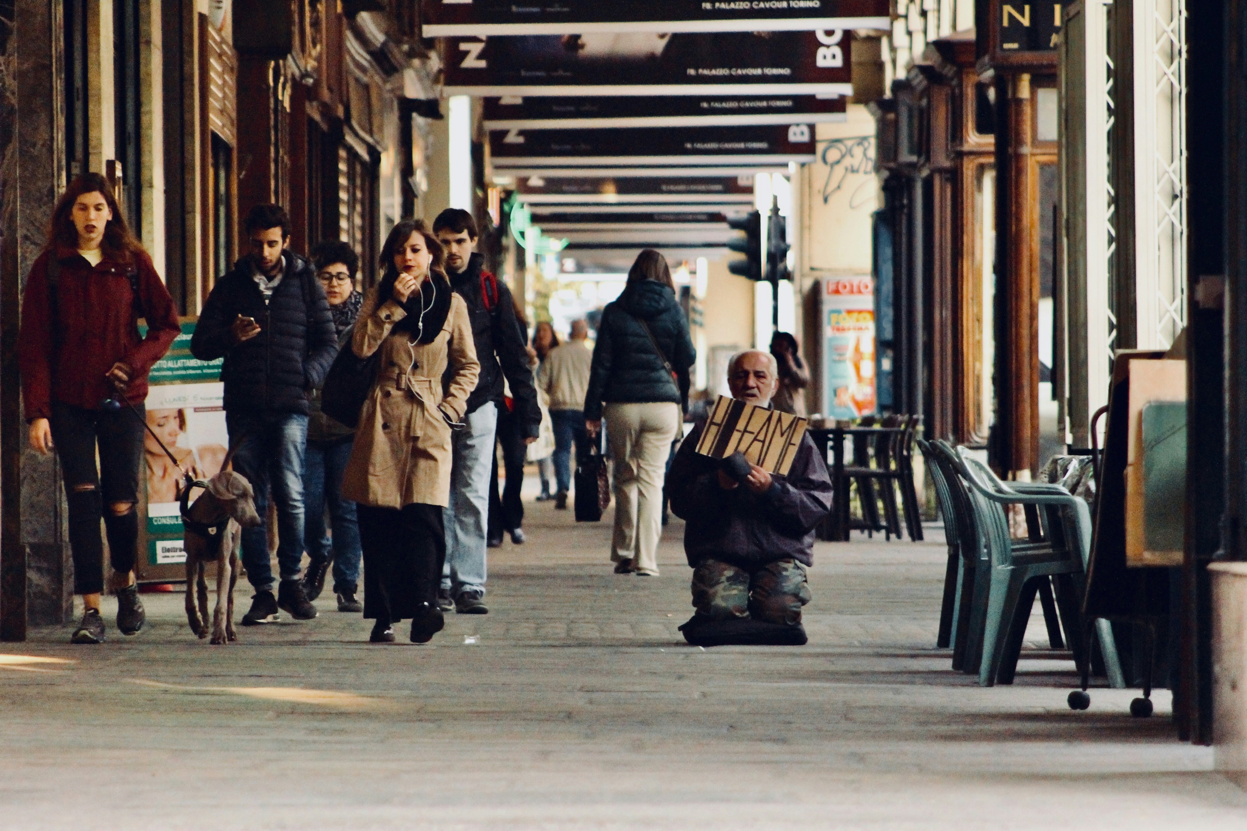 People walking by homeless person