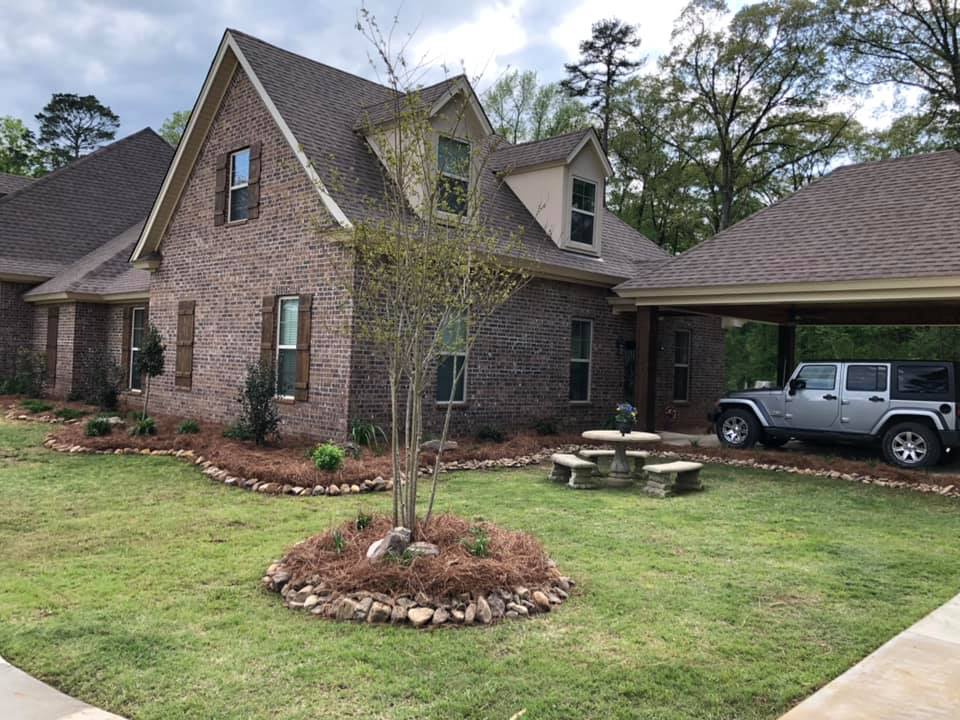 Stone-edged garden bed with annuals in Sterlington, LA