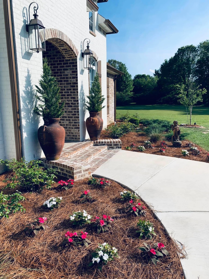 Raised garden bed with stone edging and vibrant blooms in Ruston, Louisiana
