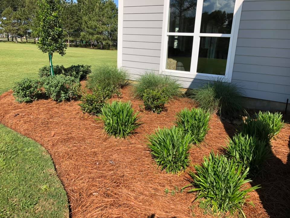 Stone retaining wall with planted flowers in Bastrop, LA