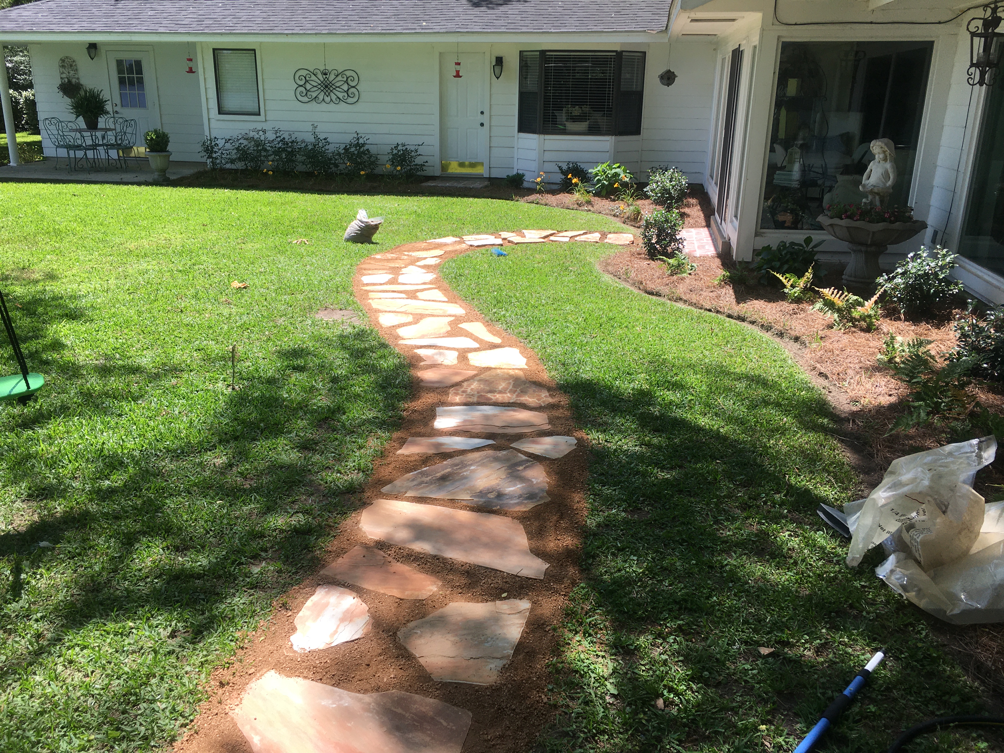 Curved flower bed with perennials and mulch in Sterlington, LA