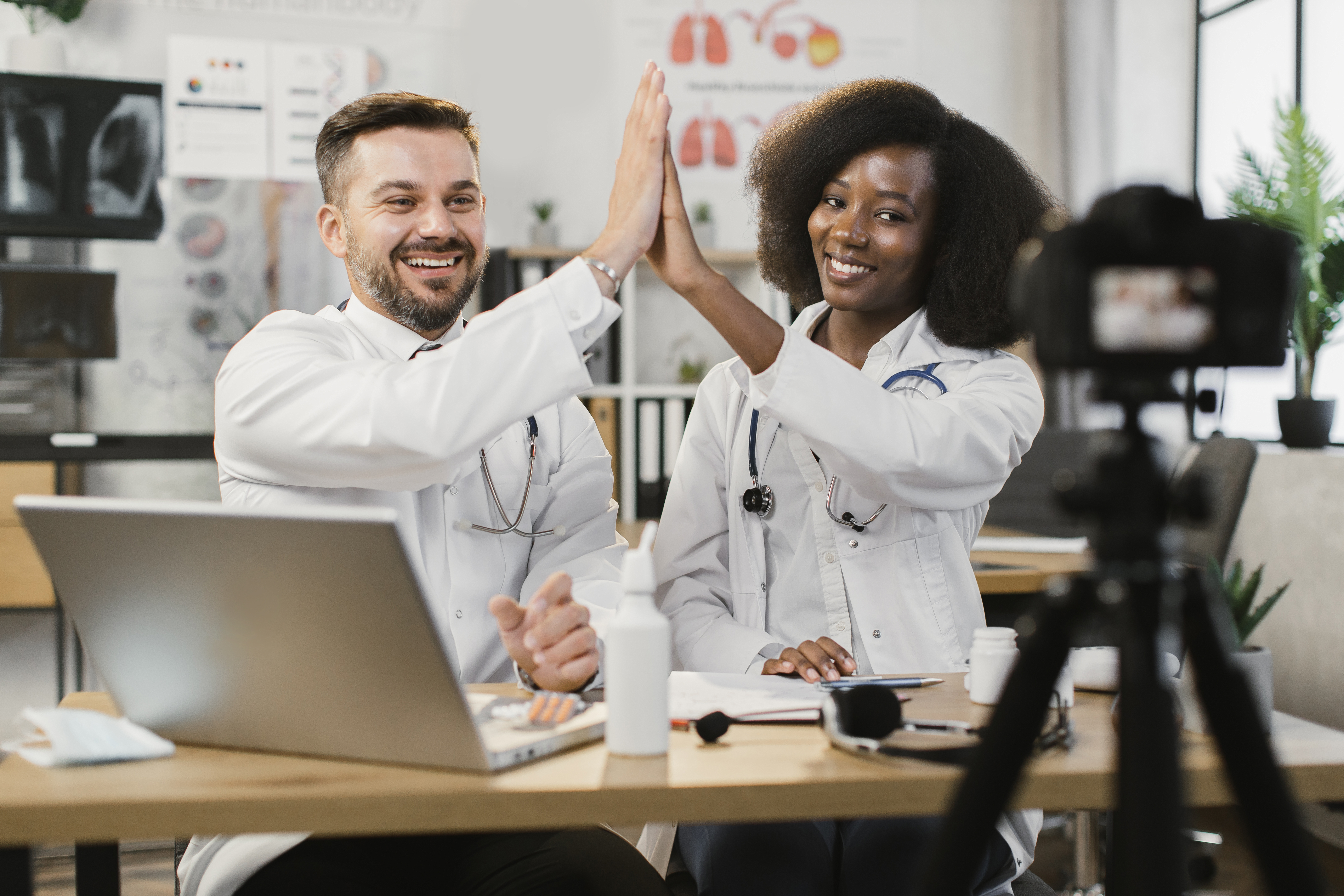 diverse doctors giving high five during vlog record diverse doctors giving high five during vlog record