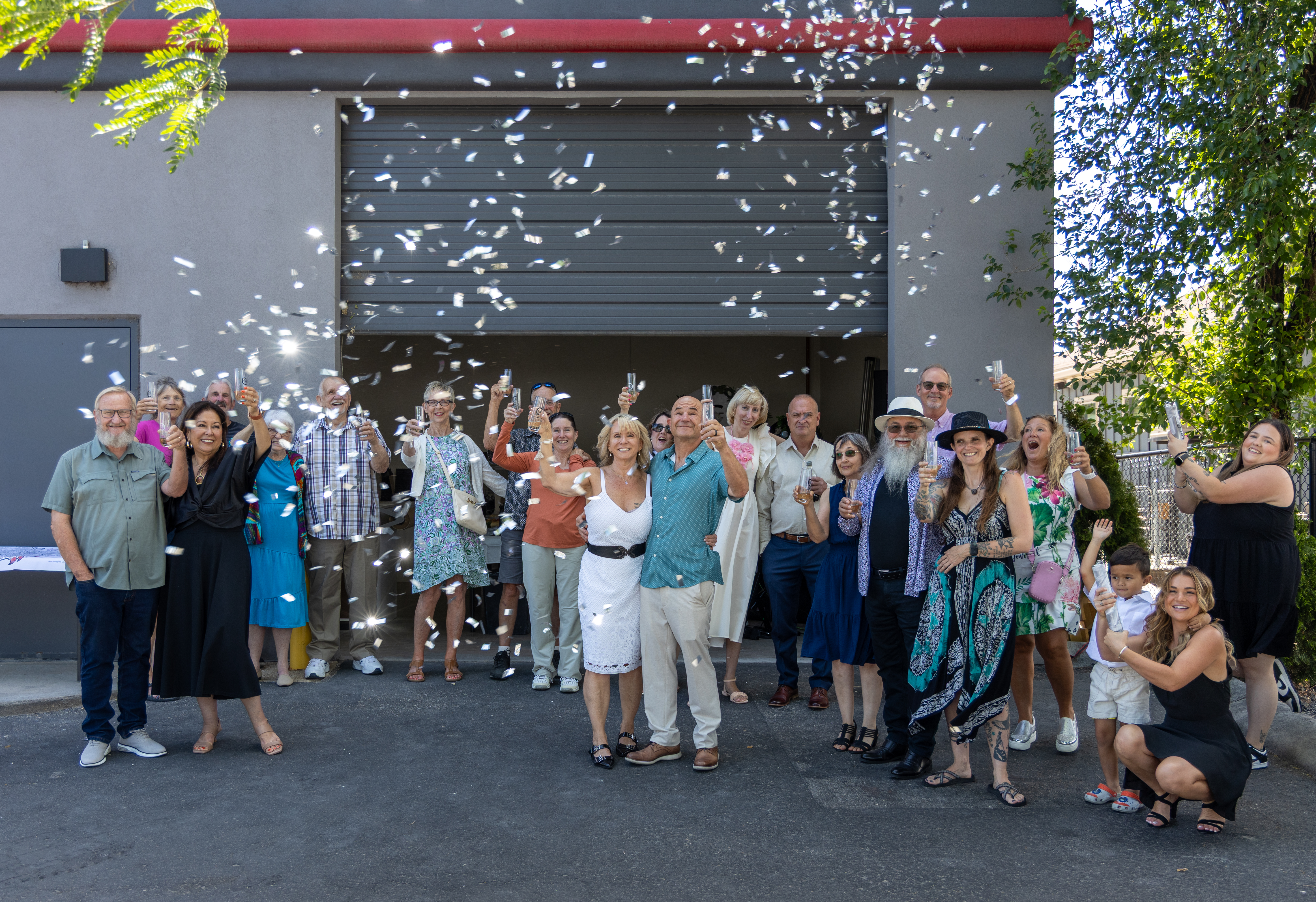group of people celebrating outside Create Gallery and Frames with confetti, marking the grand opening event in garden city, idaho.