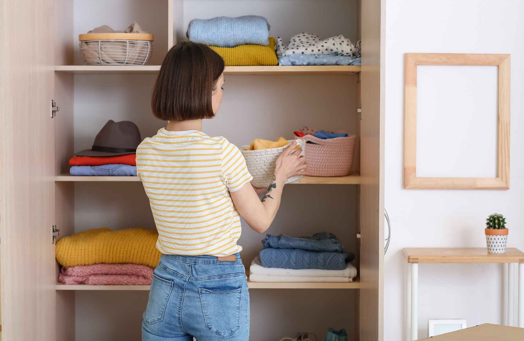 organizing-etc-kansas-city-metro-ks-our-organization-process-woman-putting-things-away-neatly-in-closet-simplify-professional-home-organizer