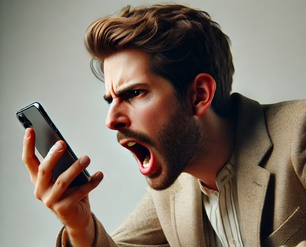 Hombre frustrado realizando una queja como cliente y gritando a su teléfono en un ambiente de oficina.