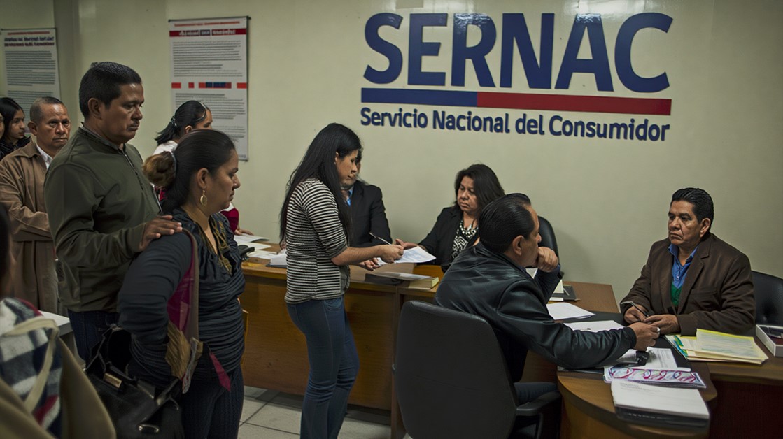 Personas presentando reclamos en oficina del SERNAC en Chile, ejemplo de atención previa a sanciones por incumplimiento normativo