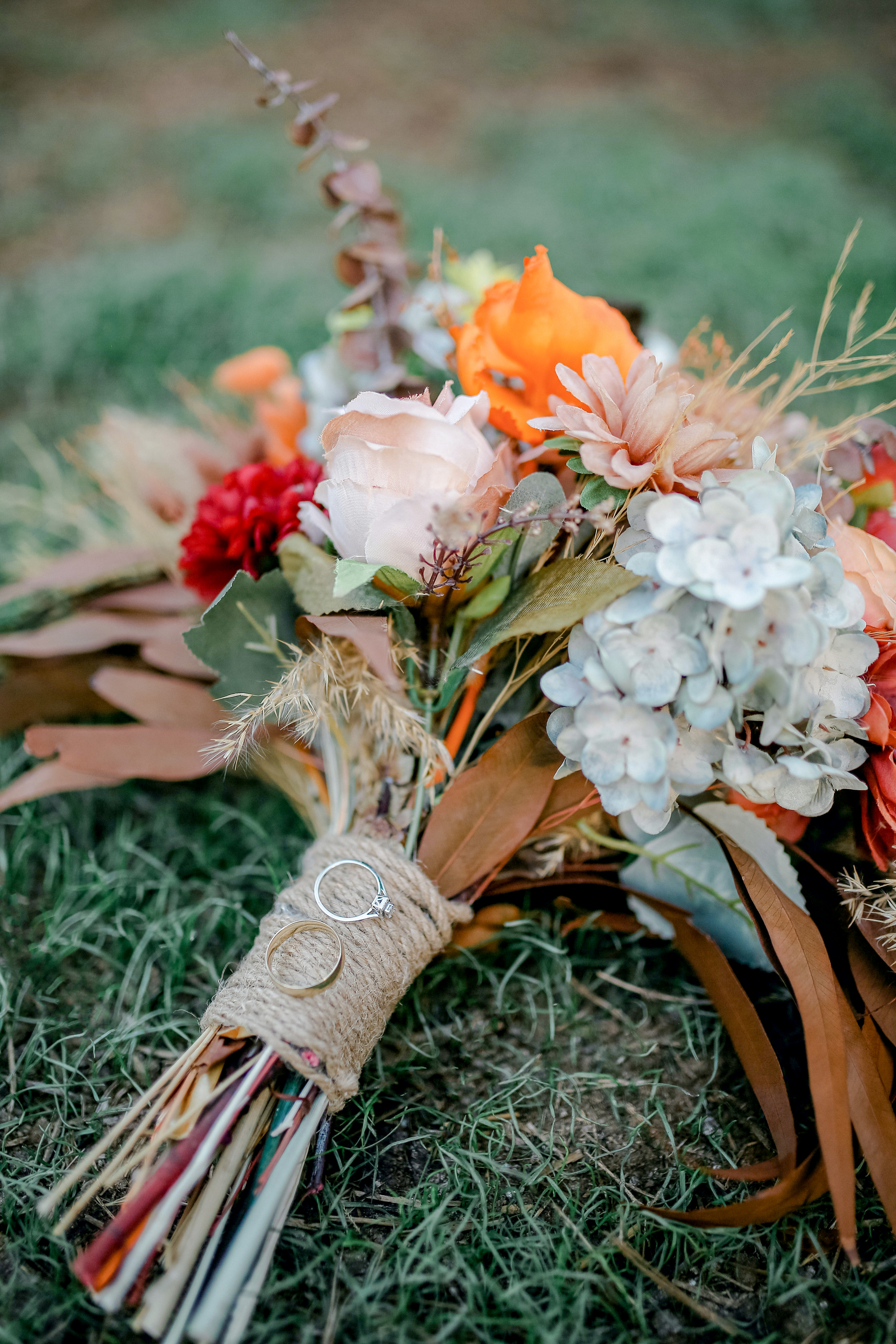 fall bridal bouquet with burlap wrap and engagement ring with wedding rings