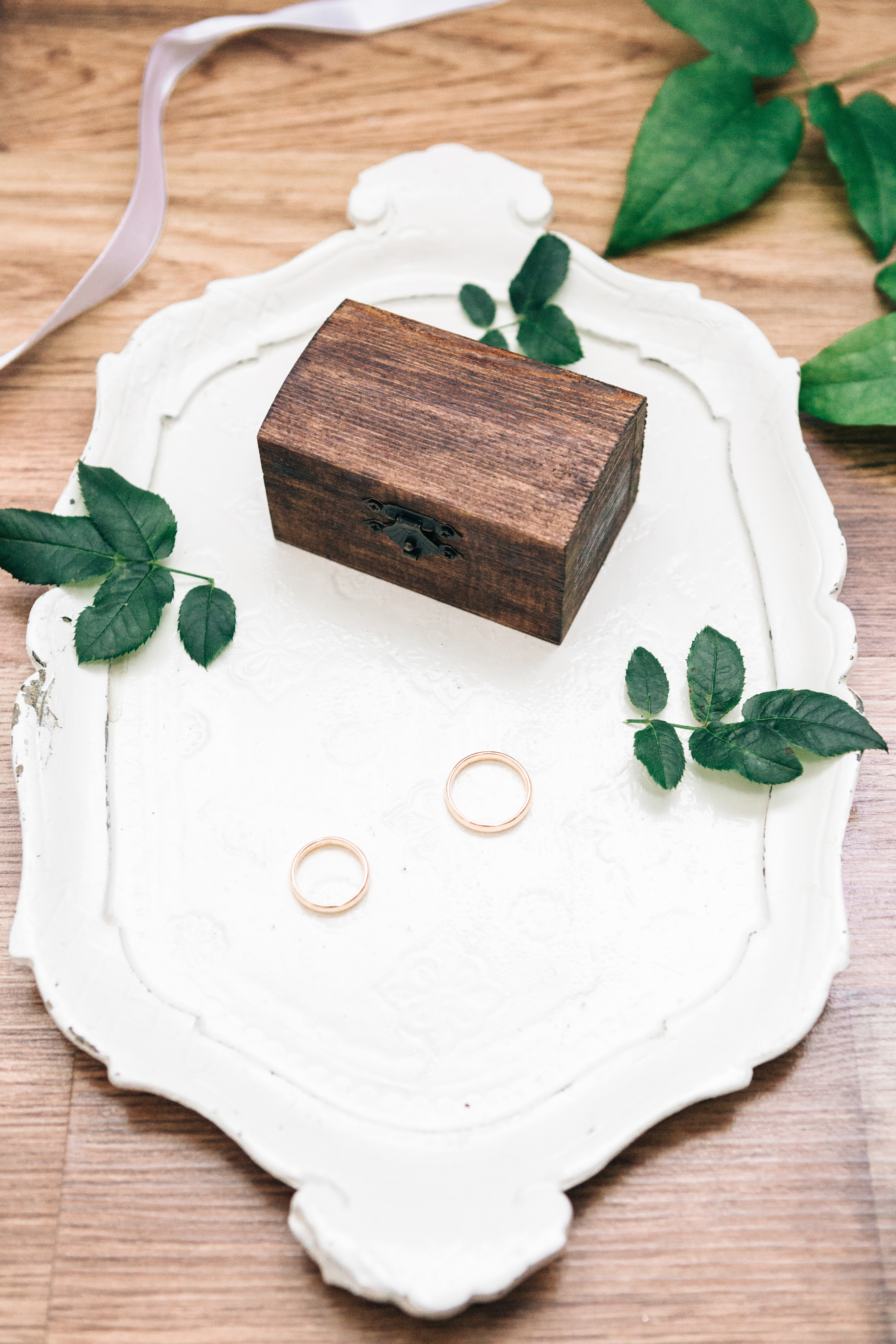 white ceramic tray holds two gold wedding bands