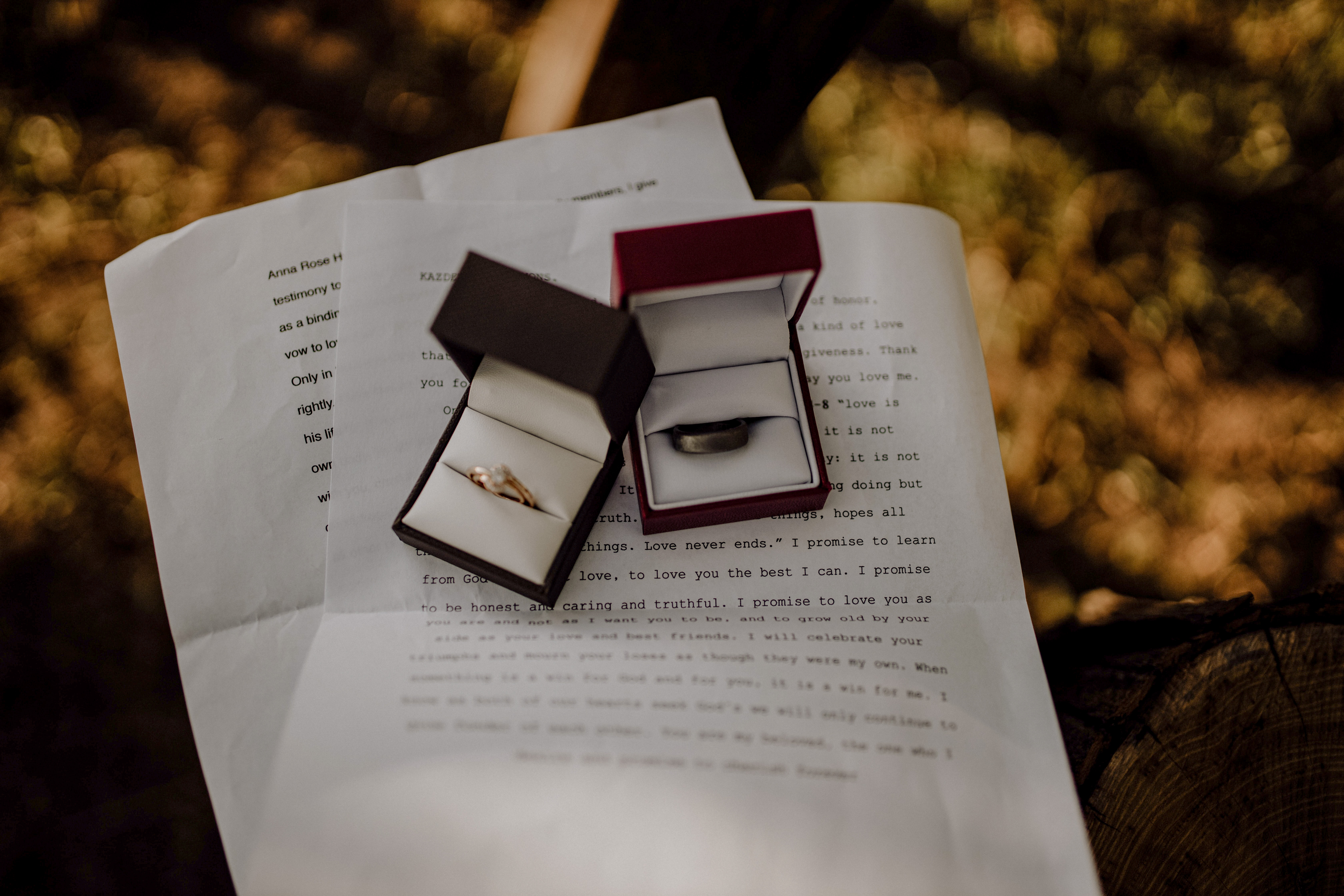 two wedding bands in ring boxes with personalized wedding vows