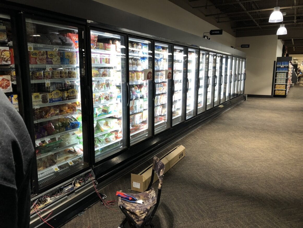 a refrigerators in a store with a cool lighting