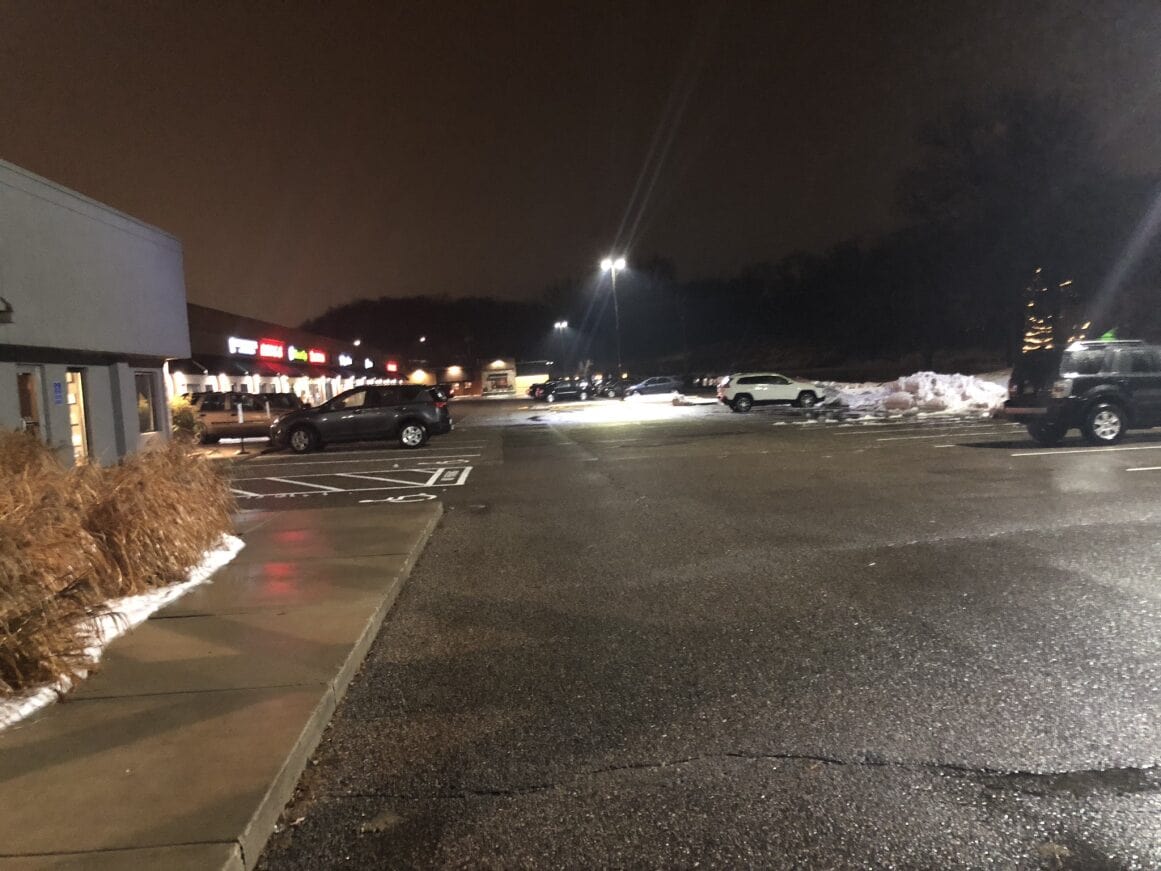 a parking lot with snow and cars with pleasant lighting