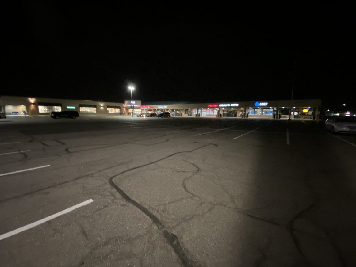 a parking lot with a building and a parking lot at night